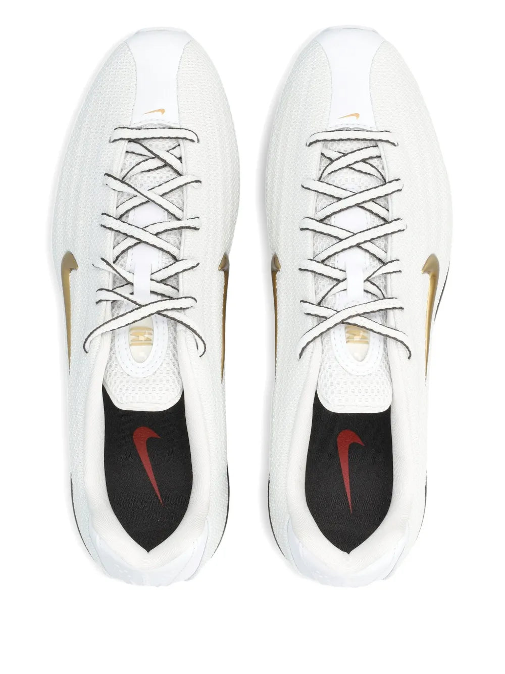 Pair of white trainers with gray laces, gold swoosh, and black interior lining