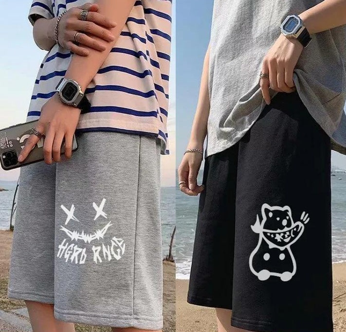 Straight sports shorts: light gray with X-eye monster graphic, black with white cartoon cat graphic.