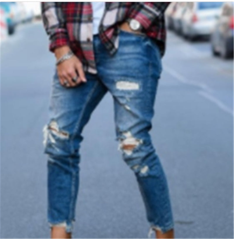 Deep blue slim jeans with ripped knees, frayed cuffs, and faded repair patches