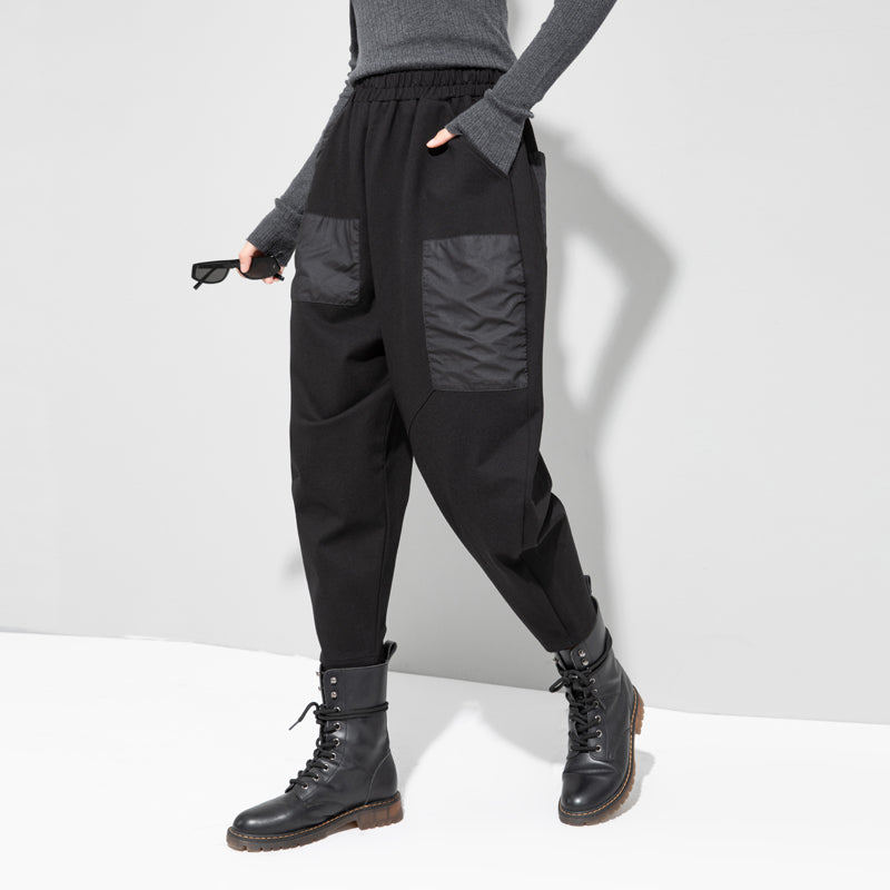 Women's black cropped cargo pants with flap pockets and elastic cuffs at hem