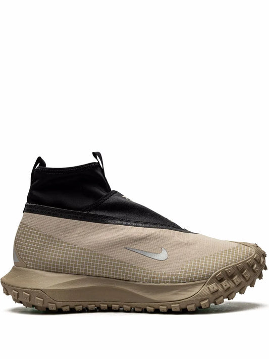 Nike ACG hiking boot with black collar, tan grid upper, rugged tread sole