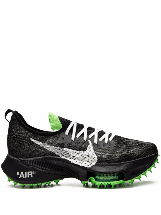 Black knit running shoe with white Nike Swoosh, green heel details, spiked outsole