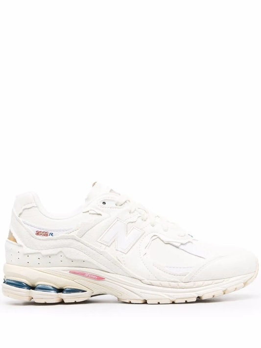 White and tan lace-up running sneakers with blue and pink heel accents