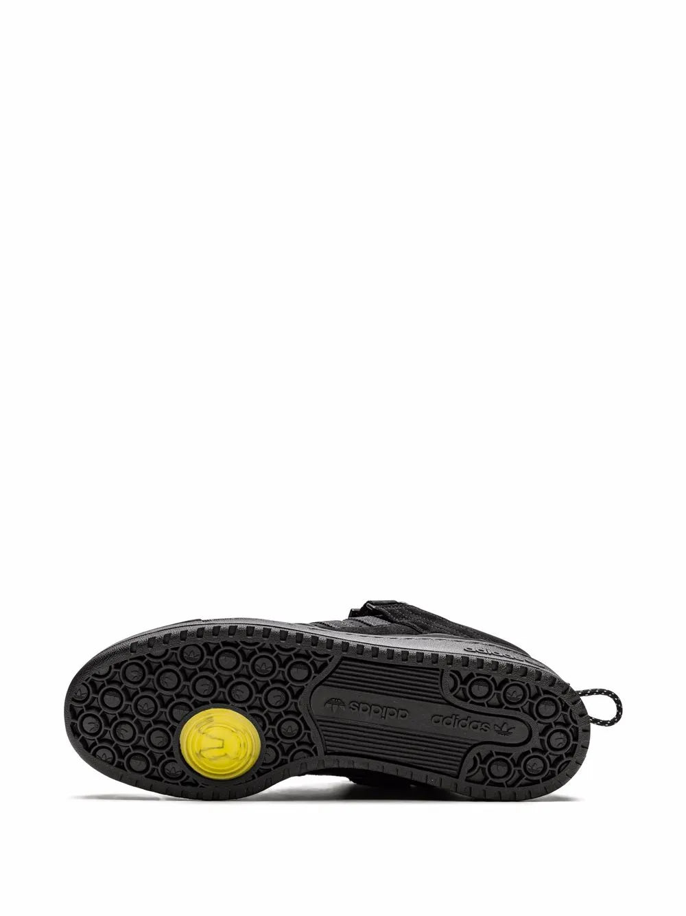 Black adidas sneaker outsole with tread pattern and yellow circular logo.