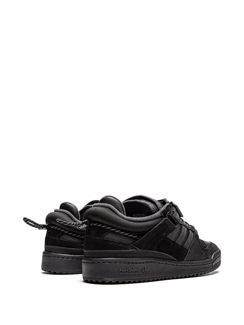 Black adidas low-top sneakers with padded ankle, buckle strap, lace-up closure.