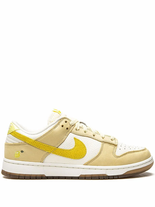 Nike Dunk Low sneakers with white leather, tan panels, yellow Swoosh, lace-up front
