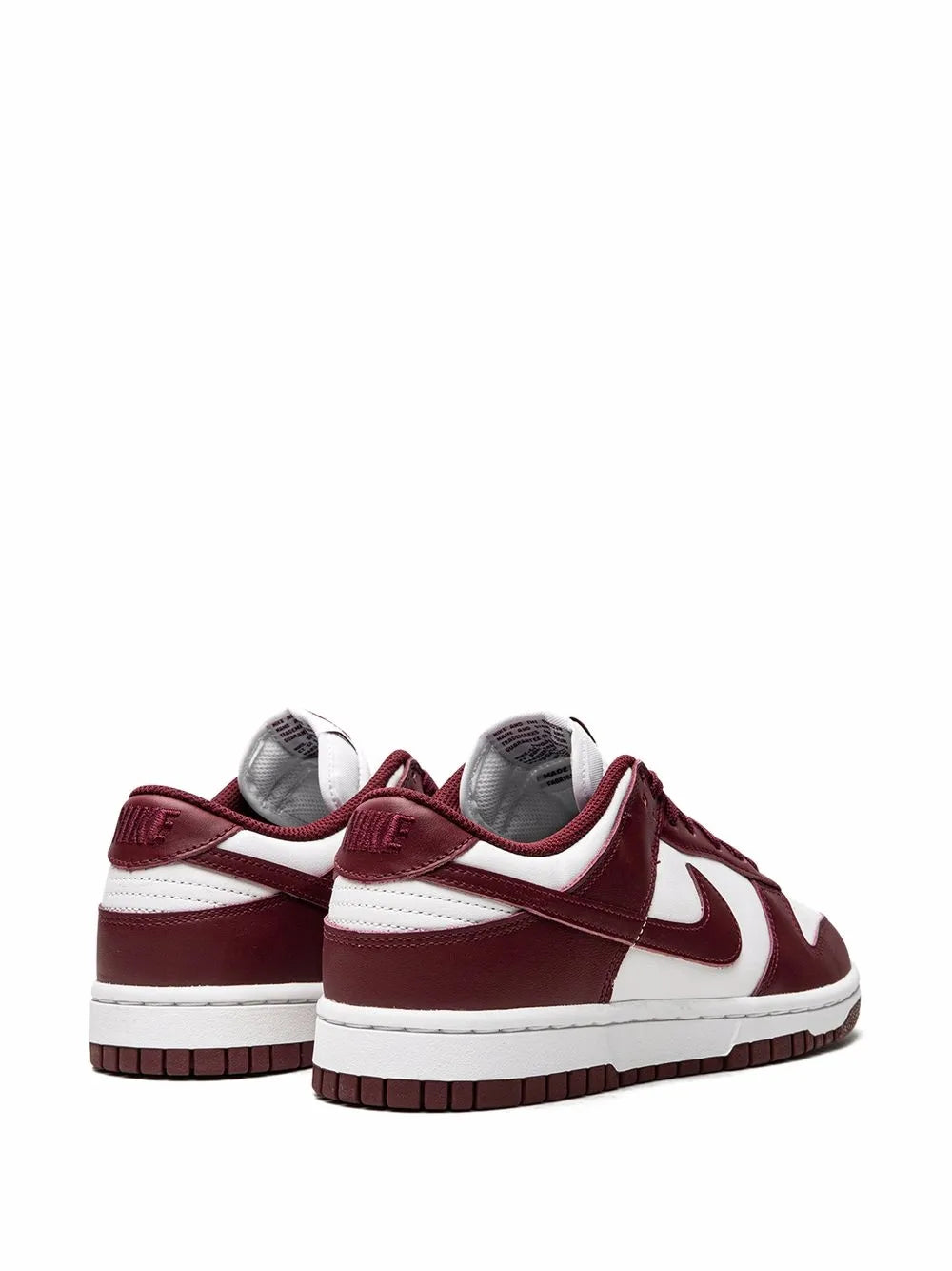 Pair of white and burgundy low-top sneakers with white swooshes and lace-up uppers