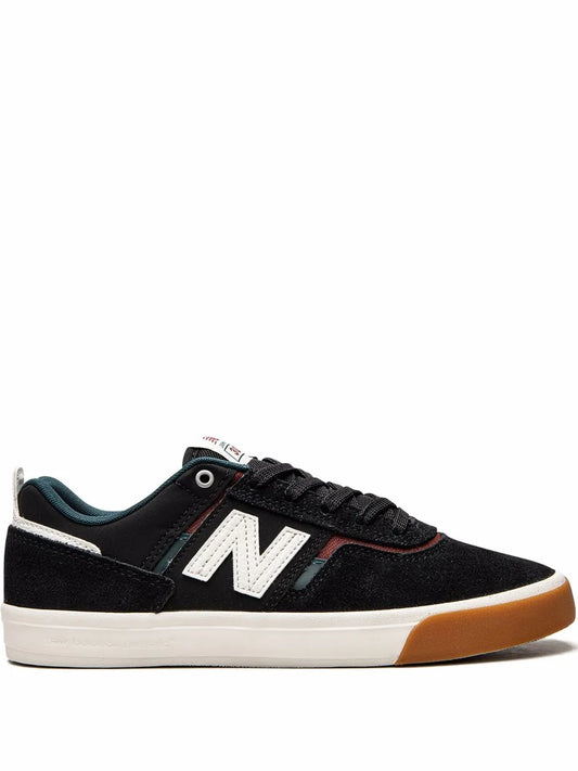 Black low-top sneakers with white N logo, black laces, tan gum outsole