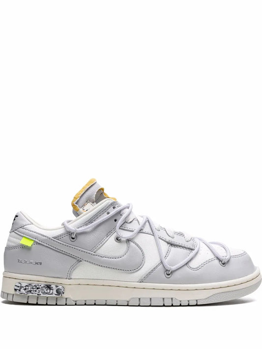 Low-top sneaker with white leather uppers, neon green lace accent, and rubber cupsole