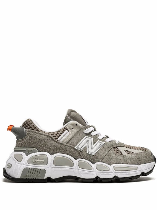 Grey and white low-top sneakers with orange lace accents and N logo