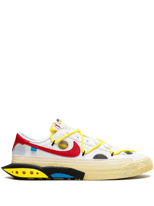Low-top sneaker with red panel, yellow laces, and beige sole with blue accents