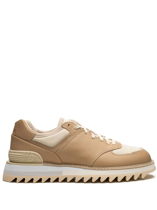 Beige low-top sneakers with tan overlays and white laces, side profile