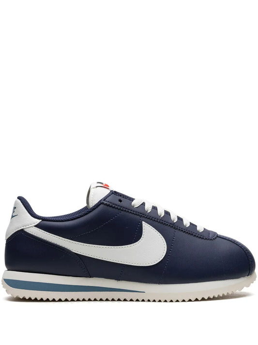 Navy leather sneakers with white swoosh, white laces, and light gum-style sole.