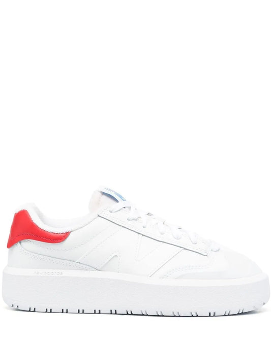 White low-top lace-up sneaker with red heel panel and blue logo detail