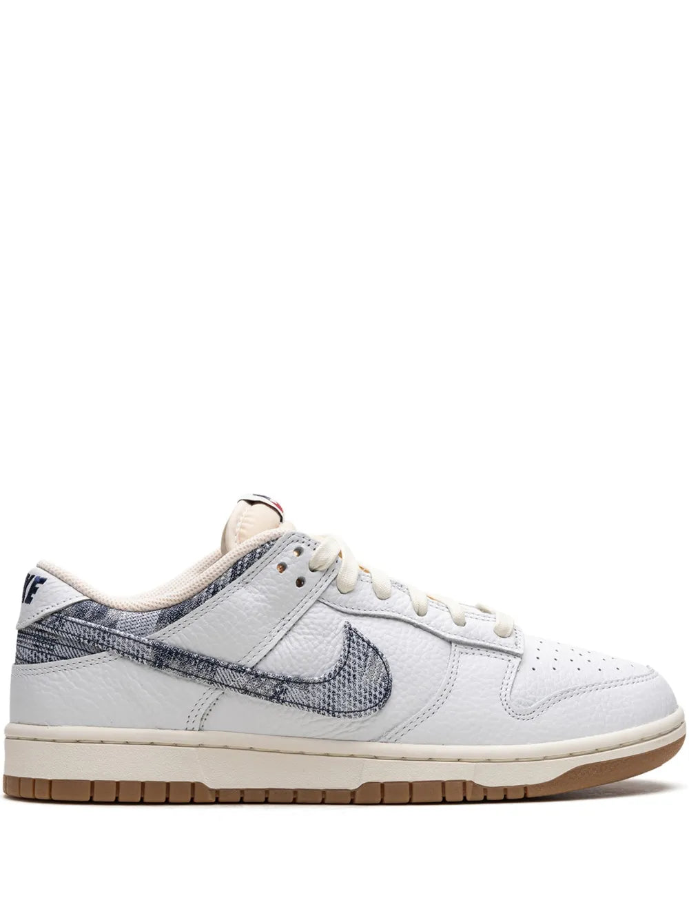White low-top sneakers with navy swoosh, cream laces, and gum rubber sole