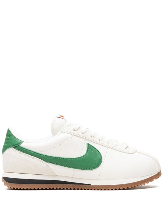 Nike leather sneaker with green swoosh, white upper, and tan rubber sole