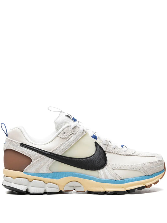 Nike Zoom Vomero 5 running shoes in white with black swoosh, blue accents and tan sole