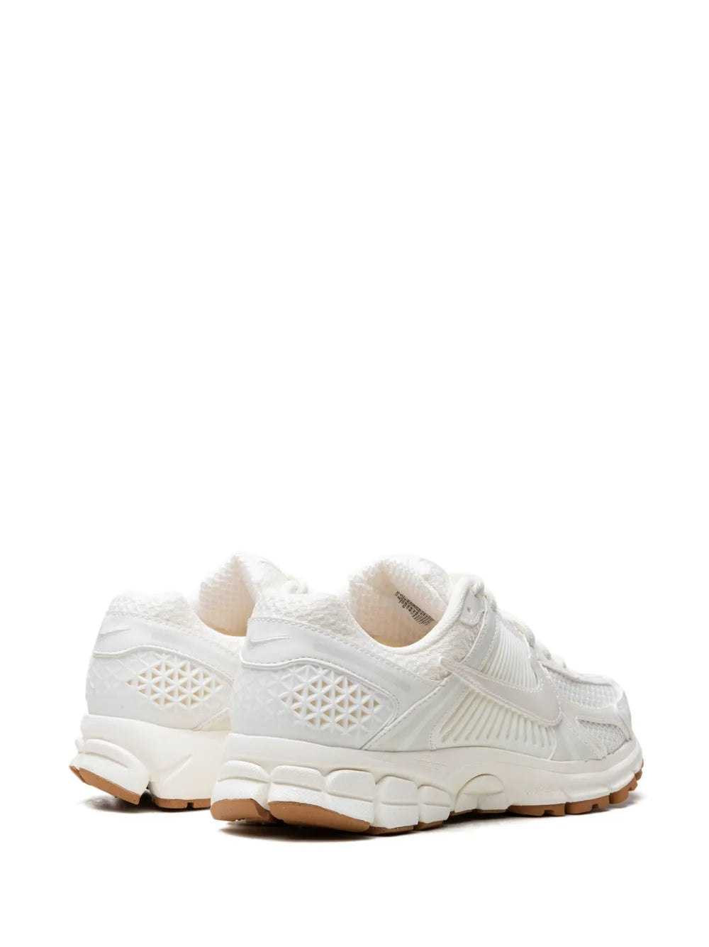 White Nike running sneakers, angled rear-side view with lace-up, cushioned midsole, tan outsole
