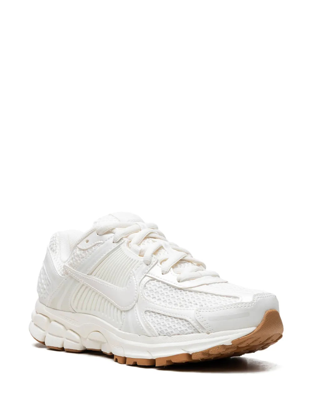 White Nike running sneakers, side view with lace-up closure, swoosh, and tan outsole
