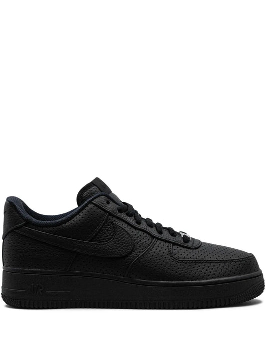 Black Nike low-top sneakers with lace-up and swoosh, perforated toe and rubber sole