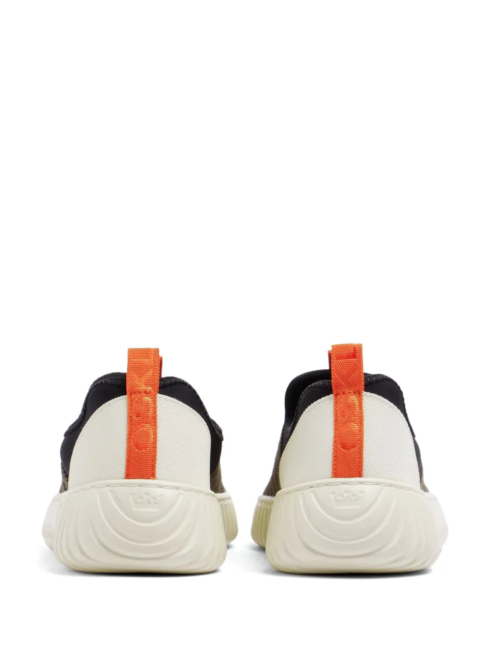 Pair of black low-top sneakers with orange heel loop and textured cream sole