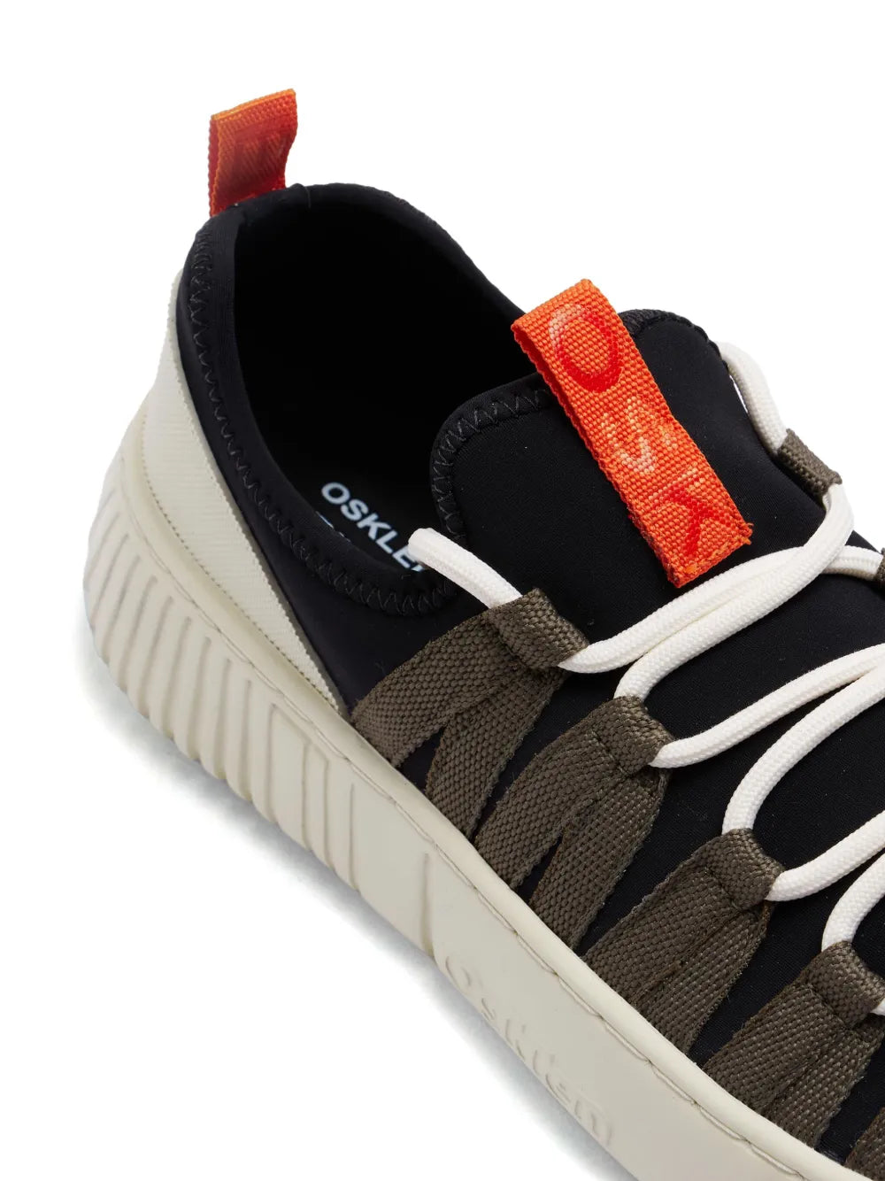Black low-top sneakers with orange strap, cushioned collar, and fabric laces