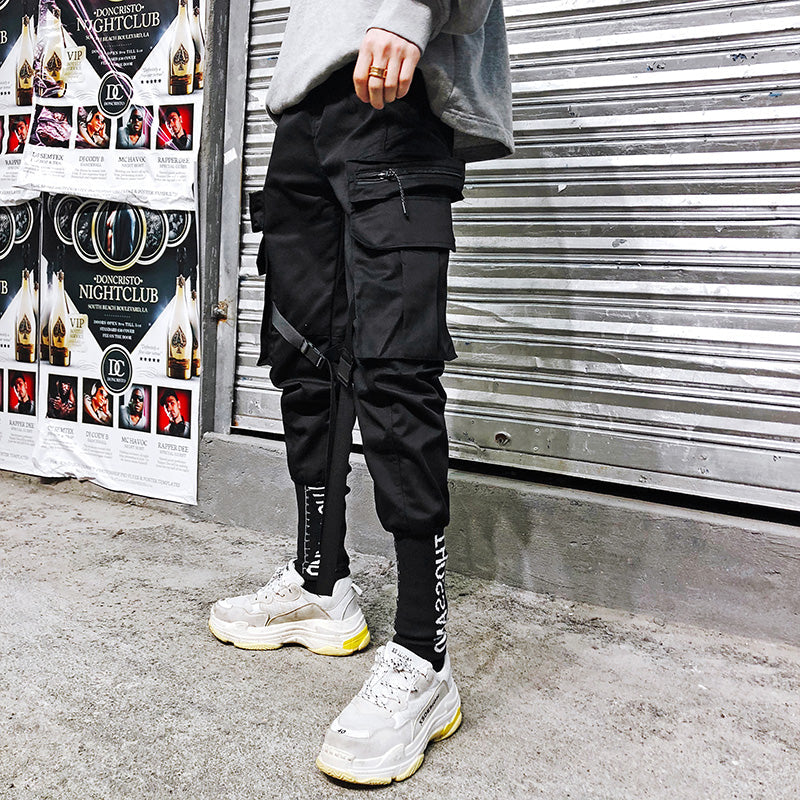 Black cargo pants with zip pockets and straight legs, adjustable side straps.