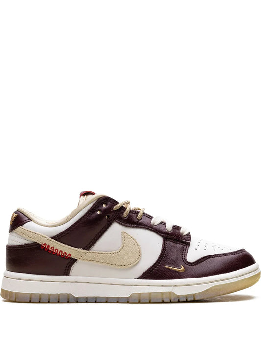 Low-top sneaker in white with dark brown panels, gold swoosh, tan gum sole
