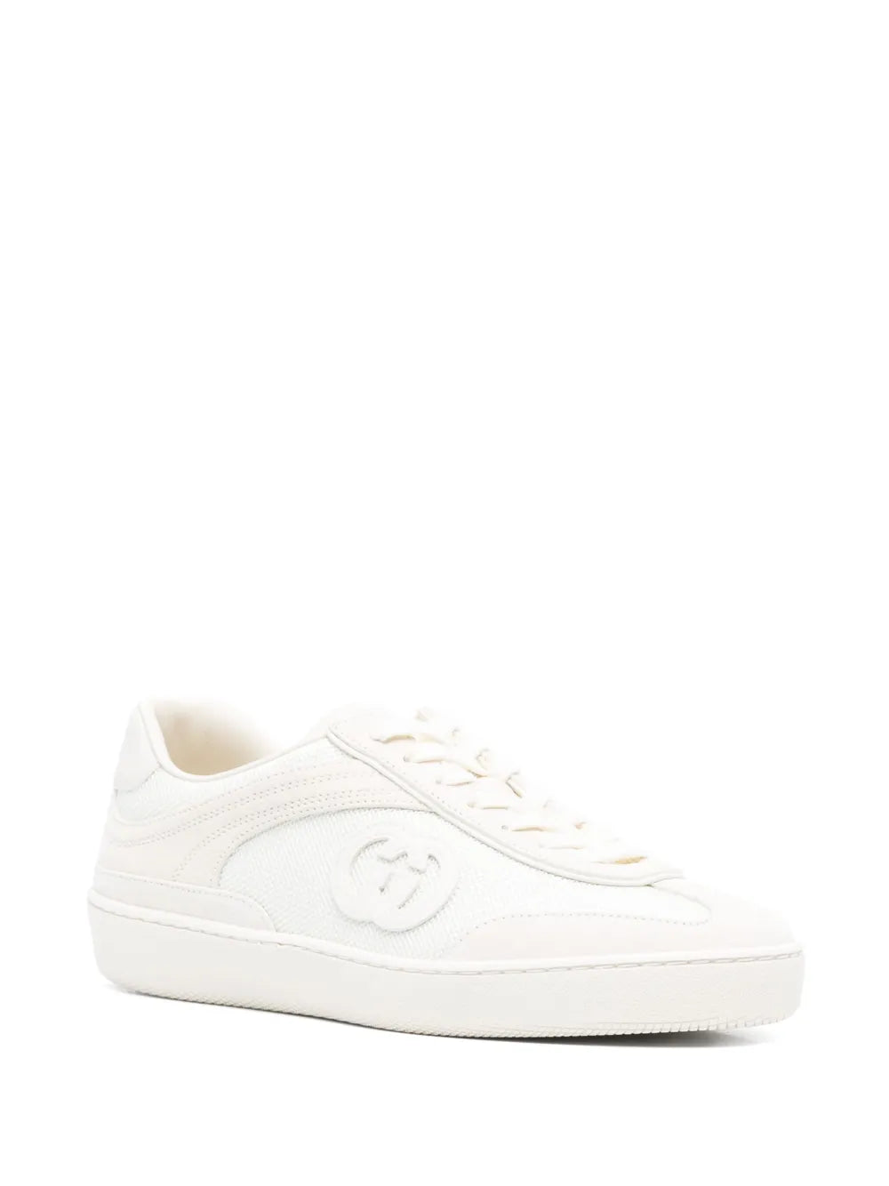 White low-top sneaker side profile with embossed emblem and lace-up