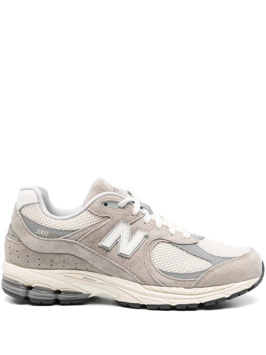 Beige New Balance 2002R lace-up sneakers with N logo and chunky rubber sole