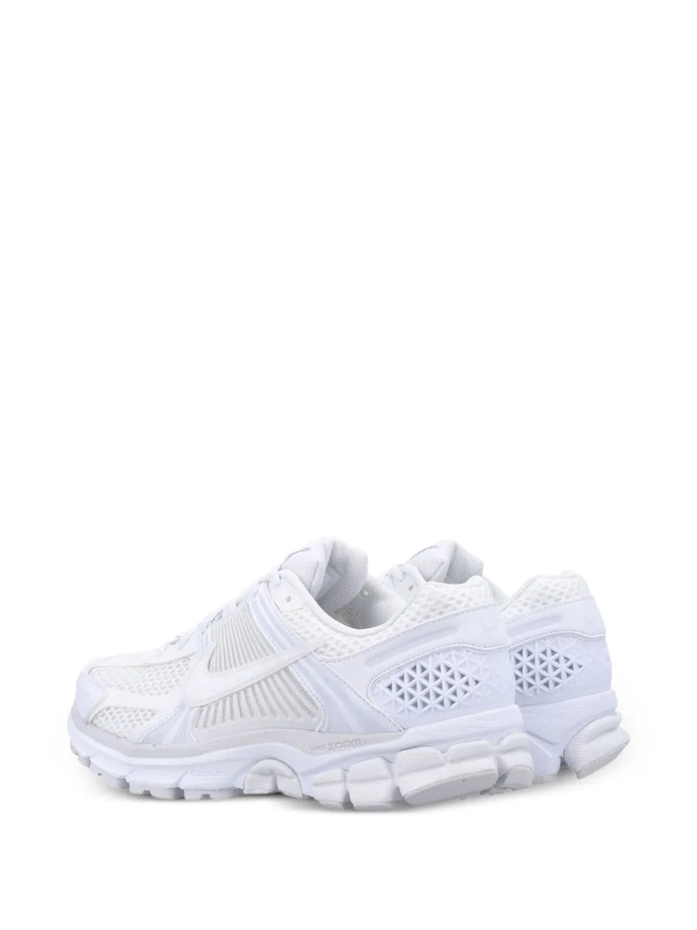 White Nike running sneakers with textured mesh upper and molded cushioned outsole