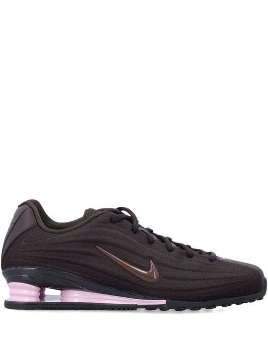 Dark brown Nike trainers with Swoosh logo and purple-tinted cushioned sole
