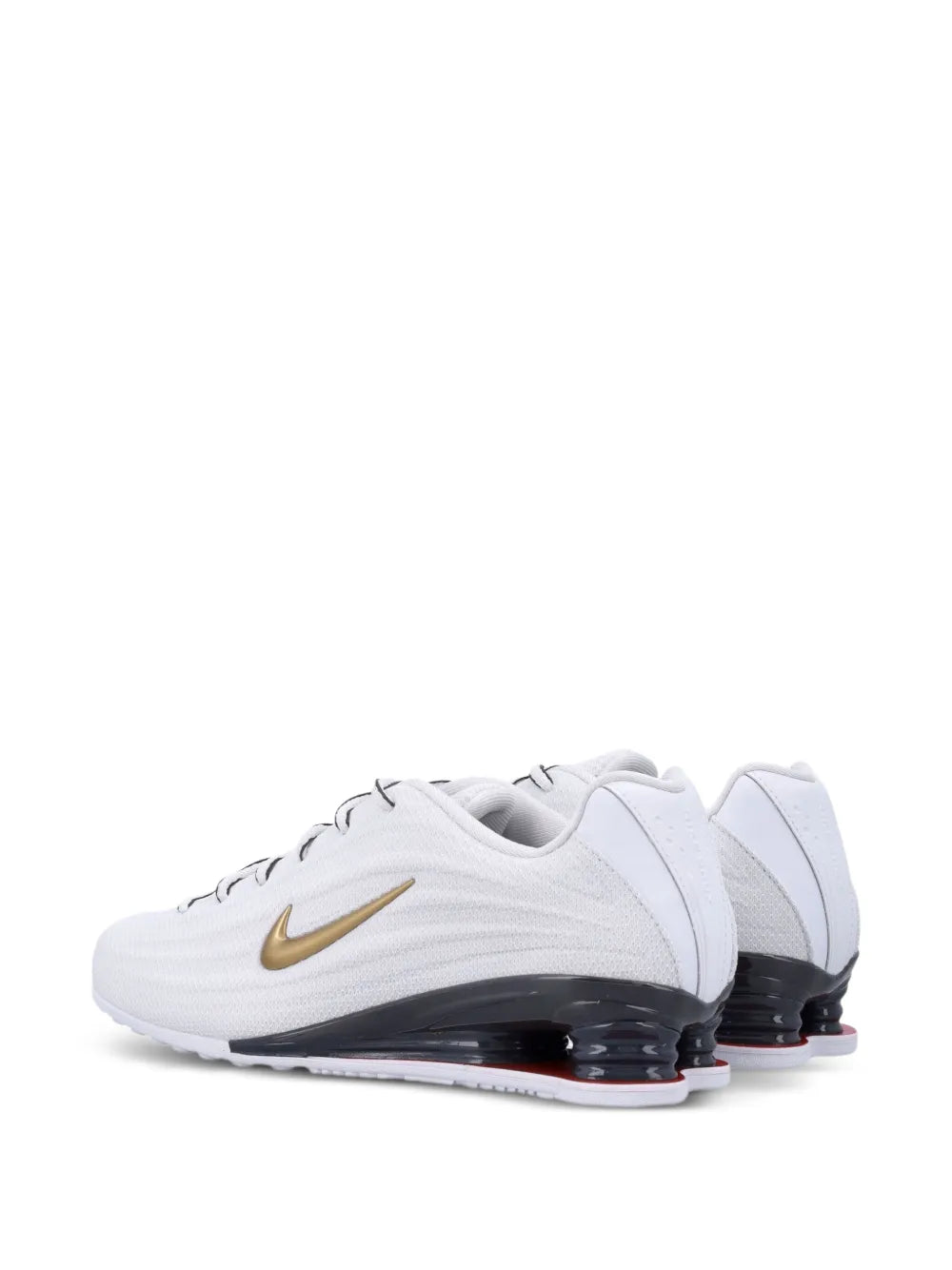 White trainers with gold swoosh and dark heel air pods, angled side view