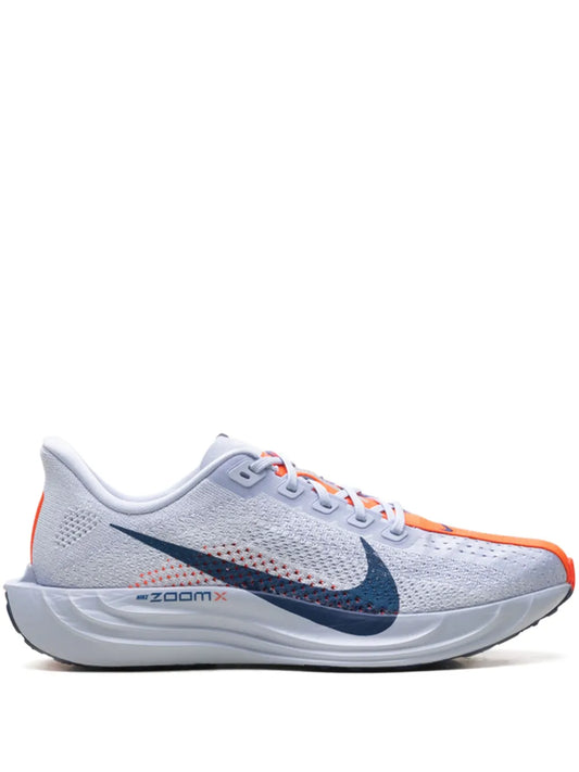 Light gray knit running shoe with navy swoosh and orange accents, lace-up design