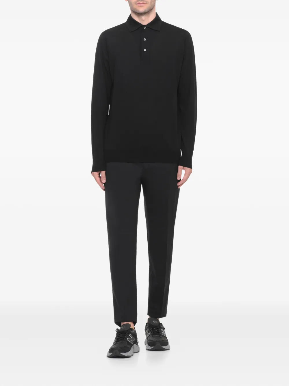 Black sneakers on model with black pants; lace-up low-top design