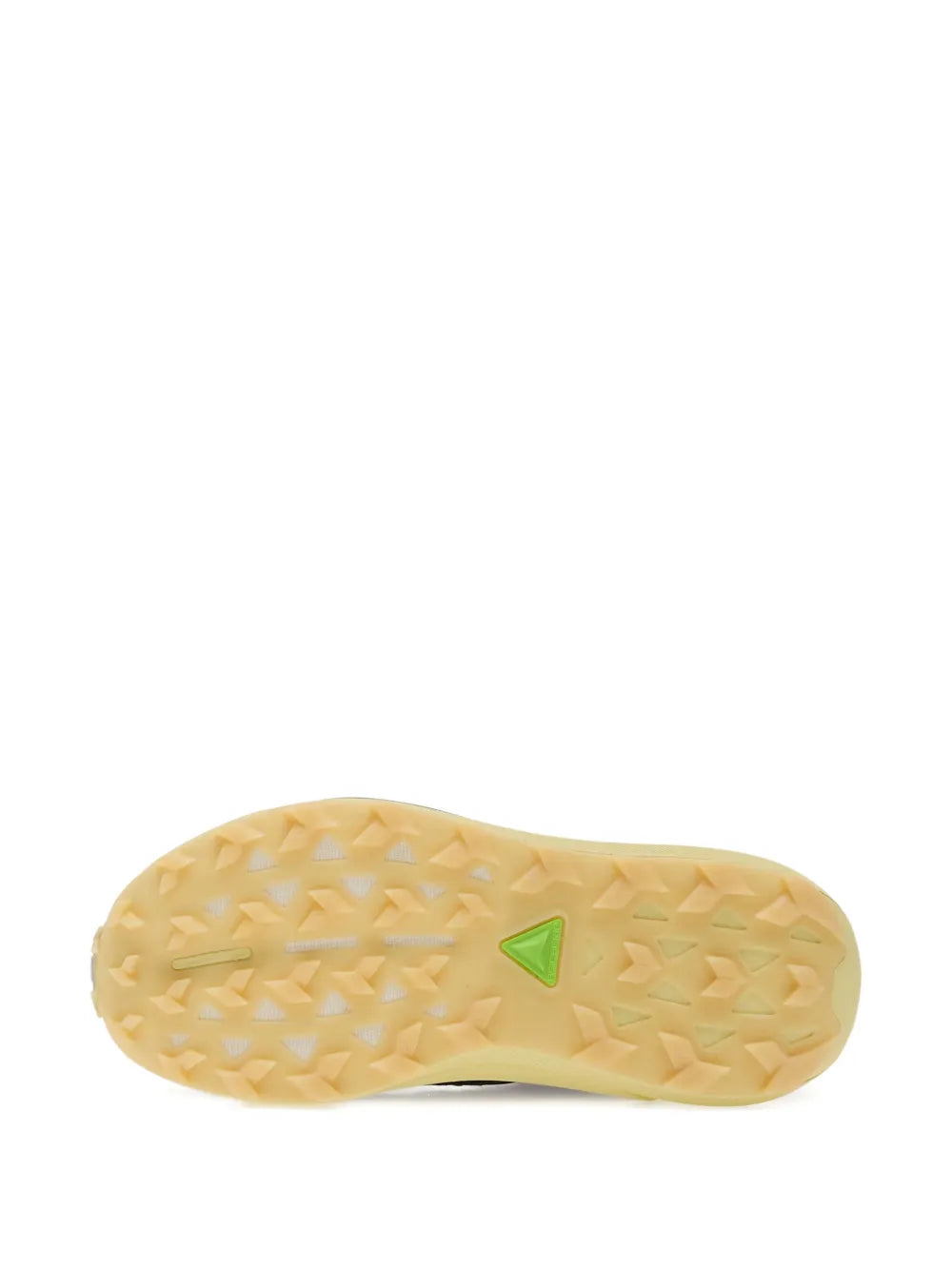 Trail running shoe outsole tread, light yellow with small green logo