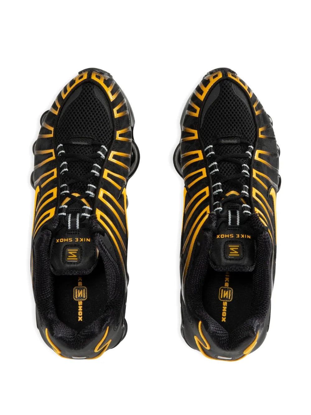 Pair of black running shoes with yellow detailing; rear view shows padded heel and lugs