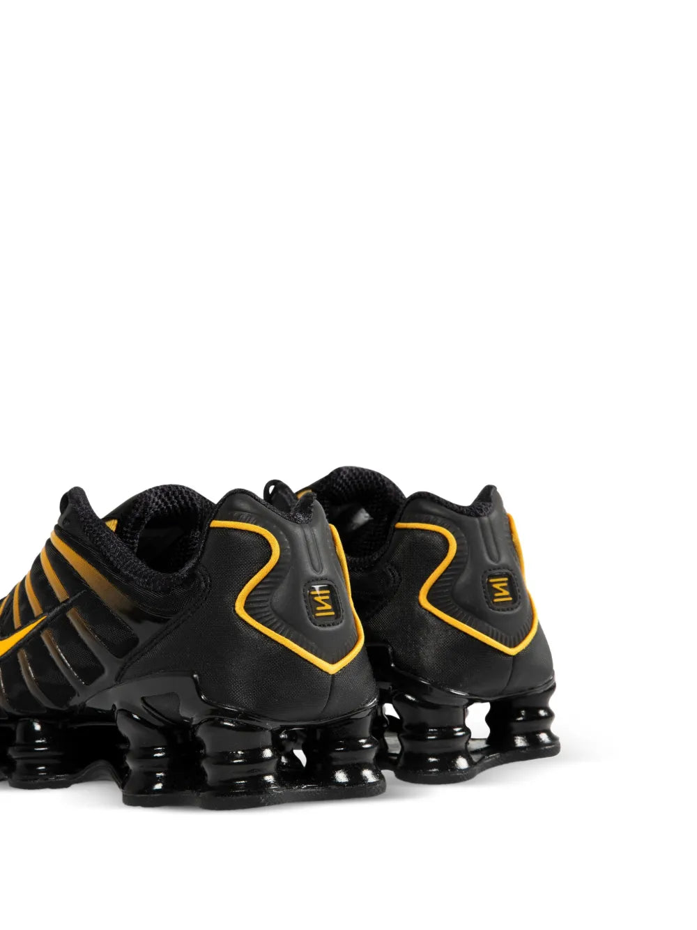 Black running shoes with yellow-trim heel and lace-up mesh; visible air pod cushioning