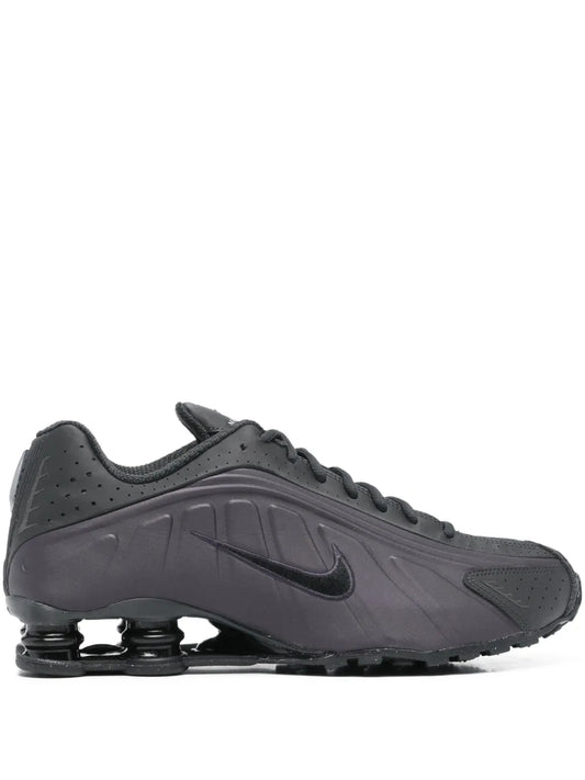 Black Nike Shox logo detail trainers, side view with Swoosh and spring pods