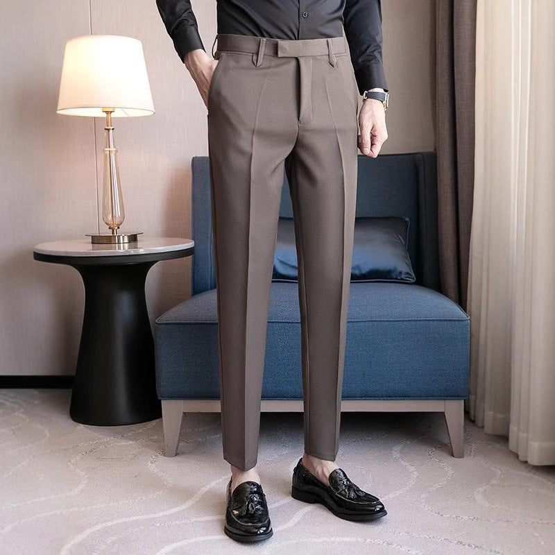 Men's dark gray dress pants with belt loops, pleated front, and tapered ankle fit