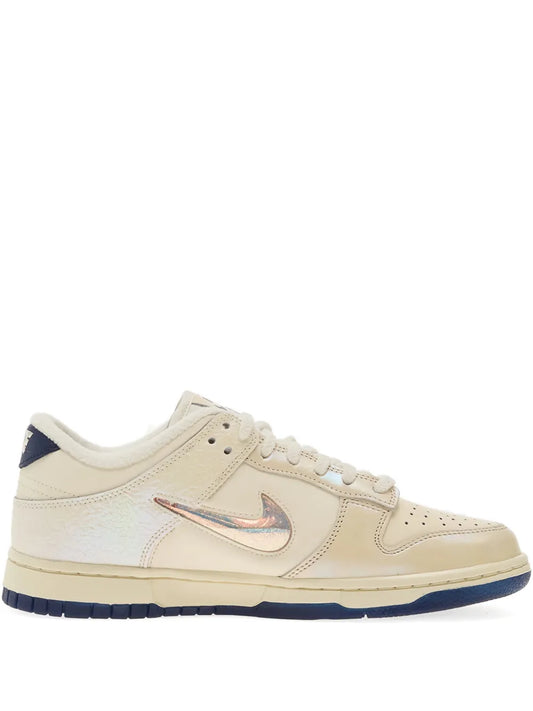 Beige Nike Dunk Low lace-up sneakers with white swoosh and blue outsole
