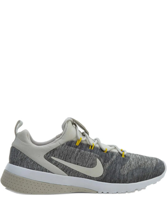 Nike grey knit sneakers with swoosh logo and light sole, lace-up.