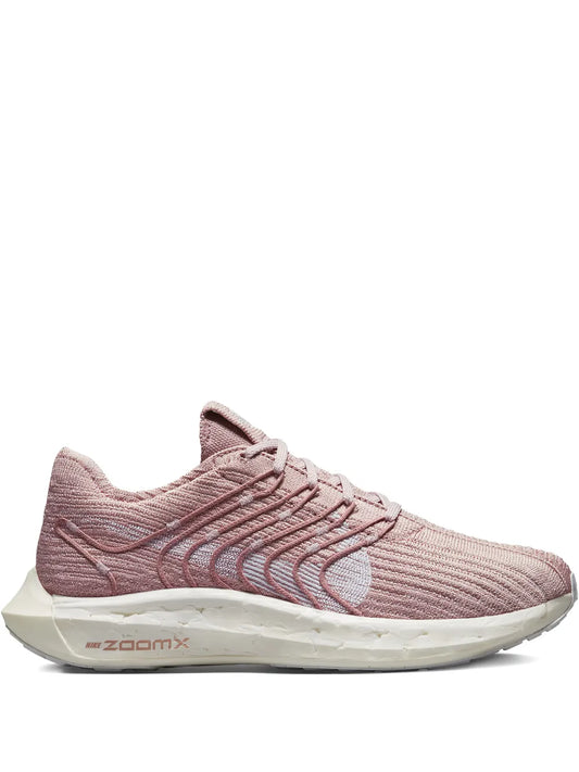 Pink lace-up running shoe with knit upper, striped overlays, and ZoomX midsole