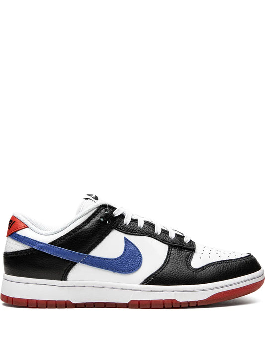 Low-top sneaker with black and white panels, blue Swoosh, red outsole.