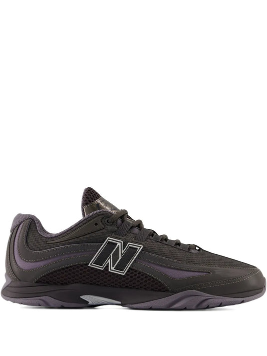 Low-top athletic sneaker in dark gray with purple accents and lace-up front N logo