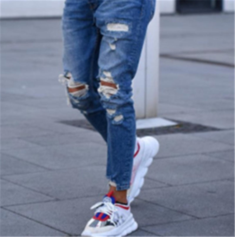 Men's deep blue ripped jeans with frayed knee rips and cuffed ankle hem