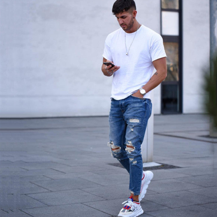 Men's deep blue distressed jeans with ripped knees and faded patchwork