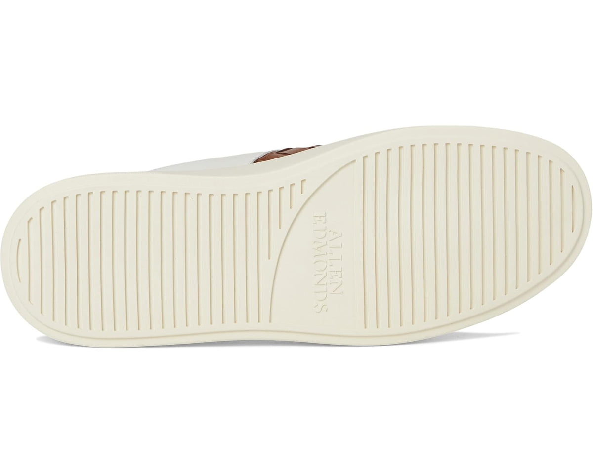 Men's white sneaker outsole with embossed brand text and grooved tread
