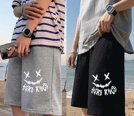 Straight sports shorts in light gray and black, both with white X-eye monster graphic.