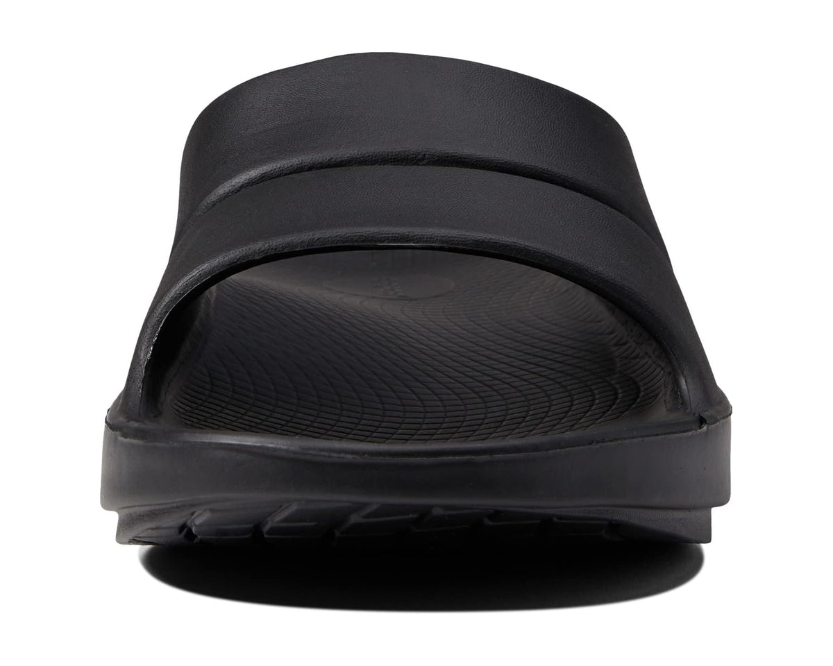 Black slide sandal top view showing cushioned molded footbed
